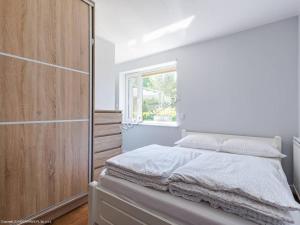 - une chambre blanche avec un lit et une fenêtre dans l'établissement Kameralny Domek(jezioro, las, klimatyzacja, Wi-fi), à Człuchów