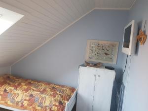 a bedroom with a bed and a cabinet with a painting at Ferienwohnung 2 - Leopold in Cuxhaven