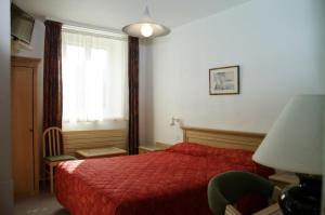 a bedroom with a red bed and a window at Les Portes du Cantal in Massiac