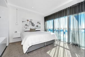 a hotel room with a large bed and a large window at The Grand Apartments in Gold Coast