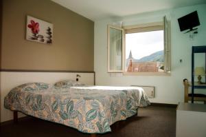 a bedroom with a bed and a window at Les Portes du Cantal in Massiac