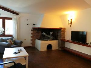a living room with a fireplace and a tv at Sera de Vall in San Antonio Bay