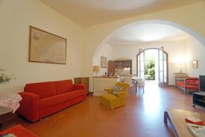 sala de estar con sofá rojo y sillas amarillas en Agriturismo Le Cerbonche, en Rosignano Marittimo