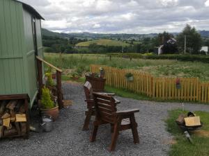 a patio with chairs and a fence and a garden at Y Cwtch in Trefeglwys