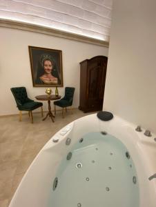 a bath tub in a room with two chairs and a table at Sweet Home Suite in Fasano