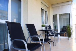 een rij stoelen en een tafel op een balkon bij Cosy Apartment In Budapest Downtown WITH Free Garage Parking in Boedapest