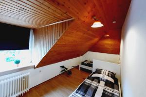 a attic bedroom with a wooden ceiling at Work & Stay Apartment mit TV & WLAN in Kleve
