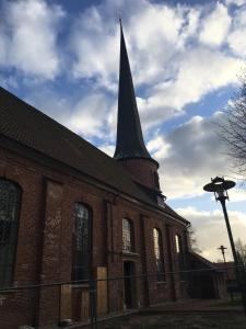 Una gran iglesia de ladrillo con un campanario encima. en Altes Pastorat, en Barmstedt
