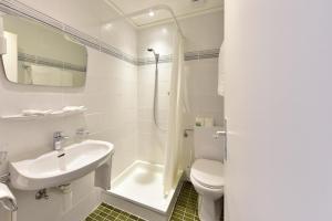 
a bathroom with a toilet, sink, and shower at J5 Hotels Helvetie & La Brasserie in Montreux
