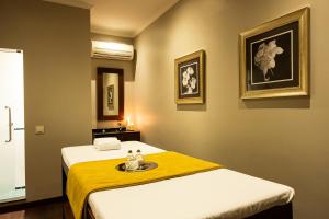 a room with two beds and a yellow blanket at Vila Gale Ericeira in Ericeira