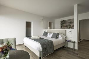 a bedroom with a large bed with white sheets and pillows at Sublimis Boutique Hotel Adults-Only in Camogli