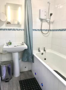 a bathroom with a sink and a bath tub and a sink at Bucklands - Chalet 15 in Westward Ho
