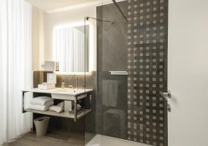 a bathroom with a sink and a shower with a mirror at Sublimis Boutique Hotel Adults-Only in Camogli