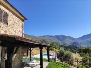 a view of a house with mountains in the background at Quinta do Torgal - Alojamento Local in Unhais da Serra