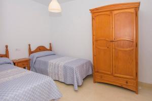 カルボネラスにあるMiramar - Corbetaのベッドルーム1室(ベッド2台、木製キャビネット付)