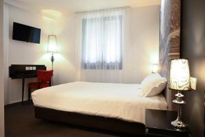 a hotel room with a bed and a window at Hôtel Les Muses in Annecy