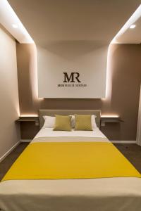 um quarto com uma cama com um cobertor amarelo em Morpheus Rooms em Nápoles