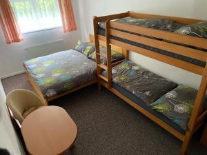 Un dormitorio con dos literas y una silla. en Chata u potoka 124, en Černý Důl