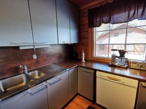 a kitchen with white cabinets and a sink and a window at Huvikallio B in Syöte