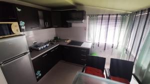 una pequeña cocina con fregadero y nevera. en Apartments Veronika, en Makarska