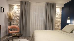 una camera con un letto e una sedia e una finestra di Etal Luxury Rooms a Dubrovnik