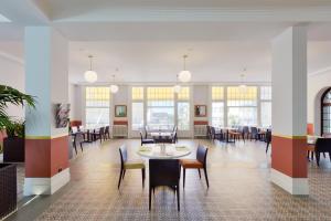 un comedor con mesas, sillas y ventanas en J5 Hotels Helvetie & La Brasserie en Montreux