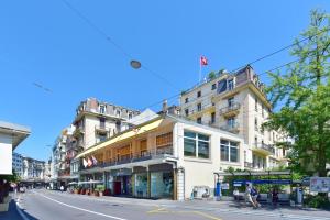 a building on a city street with people walking on the sidewalk at J5 Hotels Helvetie & La Brasserie in Montreux