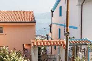 a view of the ocean from between two buildings at Traditional House Beranu Sardinia in Cala Gonone