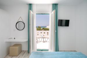 a bedroom with a door open to a balcony at Iades Studios & Apartments in Agia Anna Naxos