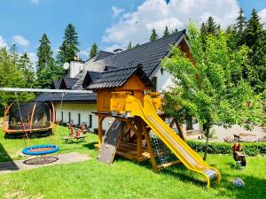 um parque infantil com escorrega e uma casa de brincar em Agroturystyka „Na Połomiu” em Istebna