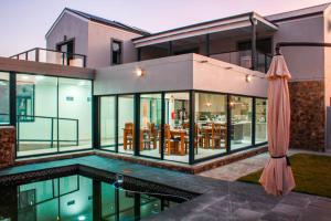 a large house with a swimming pool and an umbrella at Elizabeth House in Hermanus