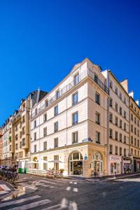 - un grand bâtiment blanc dans une rue de la ville dans l'établissement My Maison In Paris - Champ de Mars, à Paris