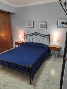 a bedroom with a blue bed and two night stands at Vokamvilia Apartments in Kini