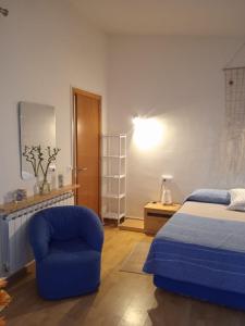 1 dormitorio con 1 cama azul y 1 silla en Triplex, en Palamós