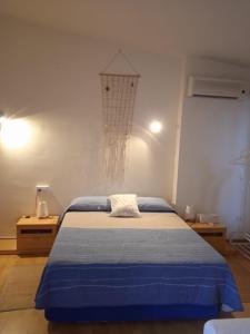 Un dormitorio con una cama azul y un aro de baloncesto en Triplex, en Palamós