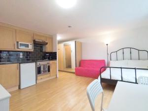 a kitchen and a living room with a red chair at Luna 218 flat 3 at Marble Arch in London