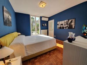 a bedroom with a large bed with blue walls at Villa Serendipità in Gardone Riviera