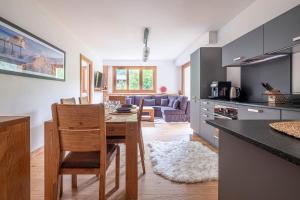 cocina y sala de estar con mesa y sillas en Au Cœur du Glacier en Chamonix-Mont-Blanc