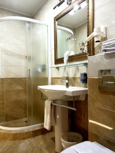a bathroom with a sink, toilet and shower at Kroshka Enot Hotel in Krasnogorsk