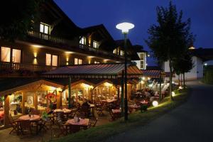 a restaurant with tables and chairs in front of a building at Musik - und Wellnesshotel Mariandl Singender Wirt in Haibach