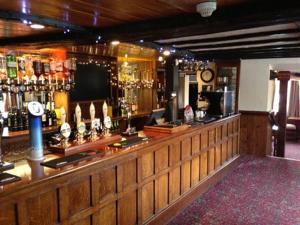 a bar in a pub with a wooden counter top at The Charlton Inn in Blandford Forum