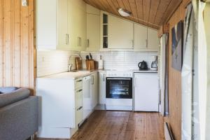 een keuken met witte apparatuur en een houten vloer bij Jølsterlia Hyttetun in Årdal