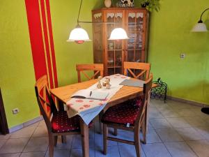 a dining room table with two chairs and a table with a book at Ferienwohnung im Landhausstil in Oberreute +18 photos