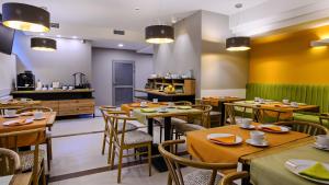 a restaurant with wooden tables and chairs and a kitchen at Hotel Brzozówka in Busko-Zdrój