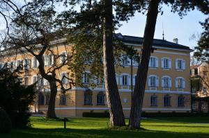 un grand bâtiment avec des arbres devant lui dans l'établissement Evangelische Akademie Tutzing, à Tutzing