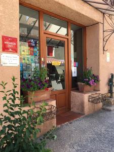 
a store front with a window with flowers in front of it at Logis Auberge Du Vigneron in Cucugnan
