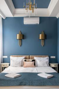 een slaapkamer met een blauwe muur en een groot bed bij Hotel Tókert Szálloda és Étterem in Lillafüred
