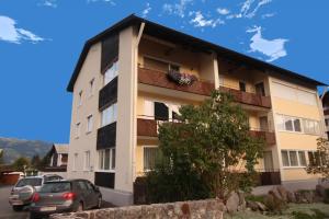 budynek z zaparkowanymi przed nim samochodami w obiekcie Apartment Alpine by Apartment Managers w mieście Kirchberg in Tirol +6 zdjęć