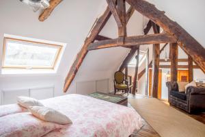 een slaapkamer met een bed in een kamer met houten balken bij L'Auberge du Coignet in Dinan