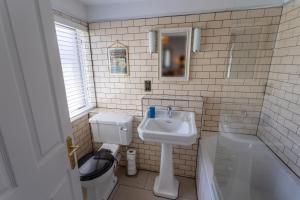 La salle de bains est pourvue d'un lavabo, de toilettes et d'une baignoire. dans l'établissement The Smugglers Inn, à Weymouth